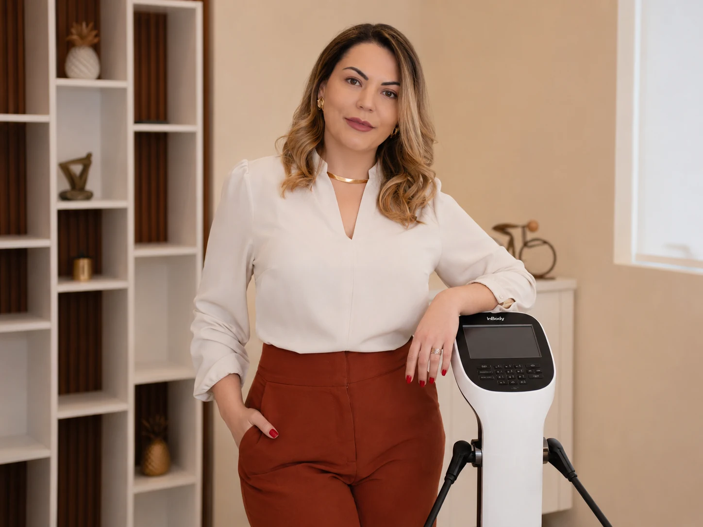 Camila Cavalari ao lado do equipamento de bioimpedância no consultório